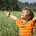 Boy praying in open field