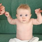 Cute baby holding onto fingers.