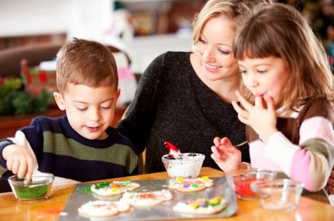 Mother decorating Christmas Cookies with her children