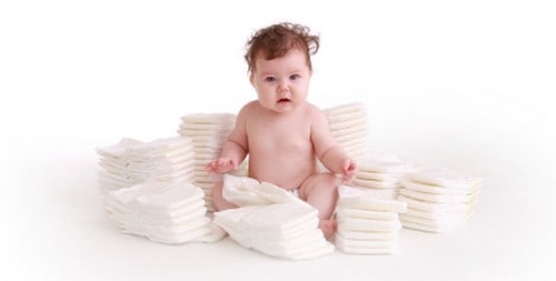 baby surrounded by diaper stacks