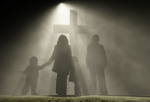 Family standing at the foot of a cross