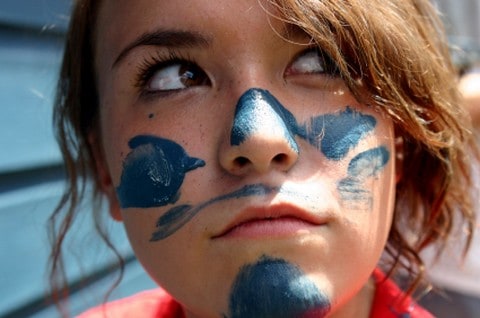 Teenage girl with paint on her face during a mission project.