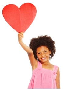 Girl holding up paper heart.