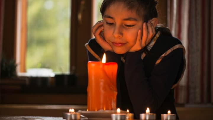 Young teenage girl meditating in candle light